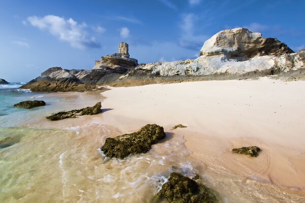 Spiaggia sabbiosa su uno sfondo di pietre possenti