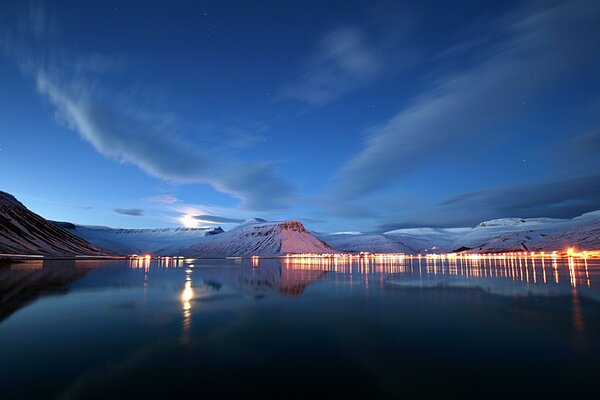 Snowy hills and a lake in the twilight