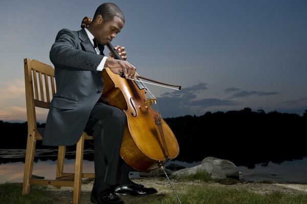 A man with a cello in nature