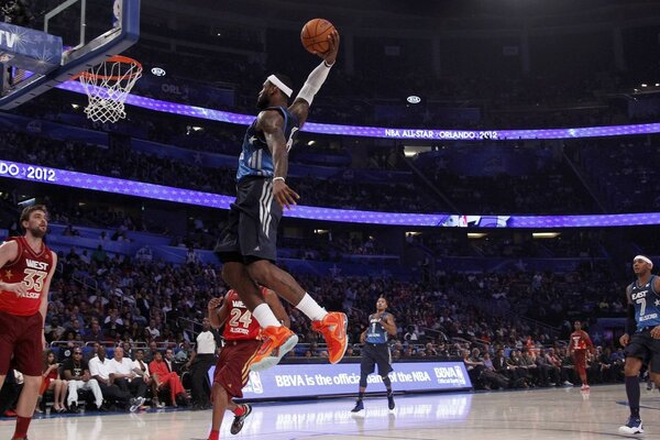 Il giocatore di basket nel salto segna la palla alla partita