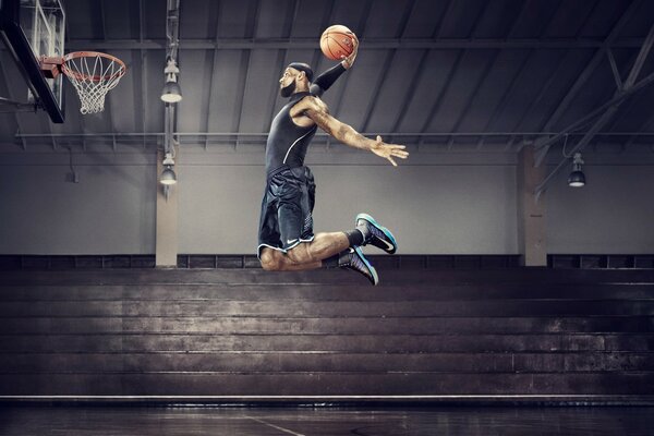 Der Basketballspieler hat mit einer Handbewegung den Ball geworfen