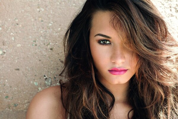 A girl with pink lips on a wall background