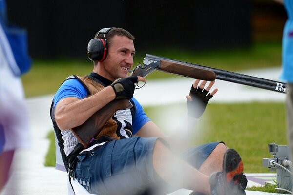 Photo of a sitting shooter with guns on skeet