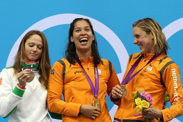 Tres campeonas olímpicas con medallas en la ceremonia de premiación