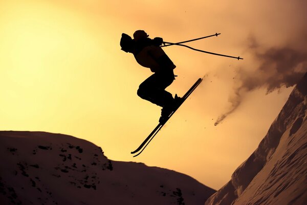 Silhouette d un skieur en sautant au coucher du soleil