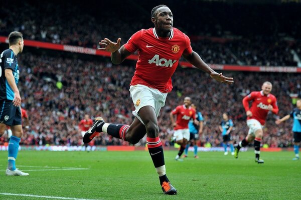 Un footballeur en uniforme Nike court sur un terrain de football