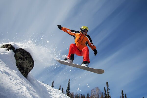 Snowboarder schwebt im Sprung über den Hang
