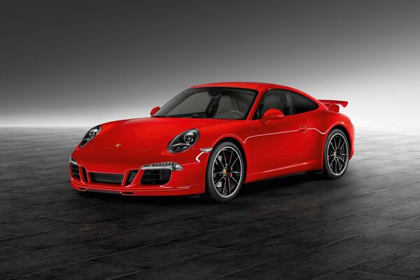 A red Porsche model on a grey table