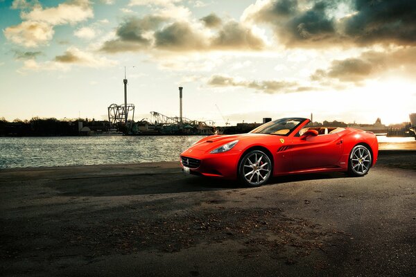 Автомобиль Ferrari California на пирсе у реки