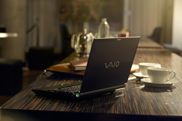 Computer on the background of coffee cups