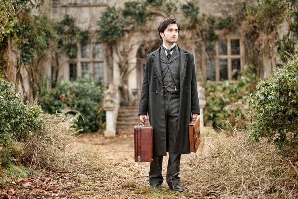 A man in antique clothes with suitcases