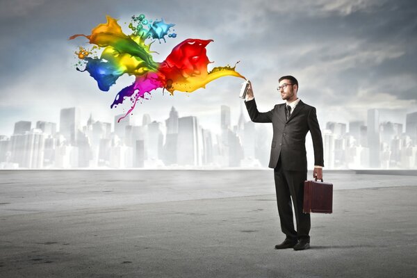 A man in a formal suit splashes with multicolored paints