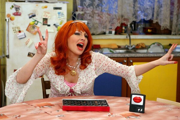 A red-haired woman in a Soviet kitchen with a cleavage sings