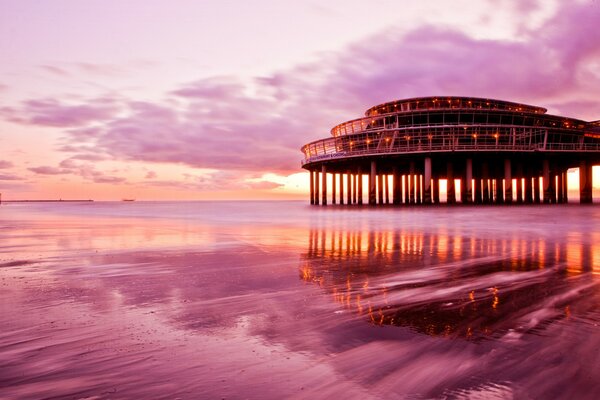 Pink beach at sunset on the background of the building