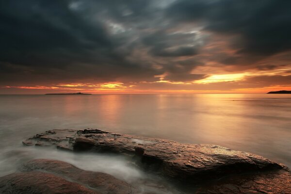 Landschaft mit Nebel und Sonnenuntergang am Meer