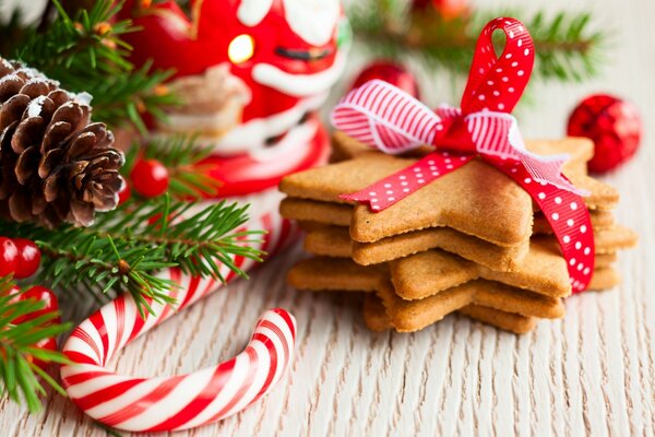 Ginger cookies in the form of stars lying next to Christmas tree branches and a cone