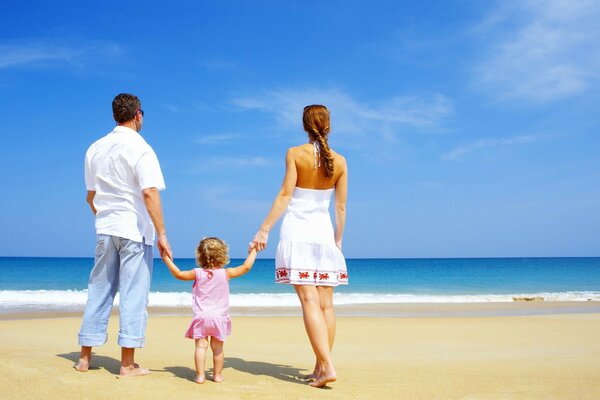 Famille avec un enfant sur le rivage de la mer