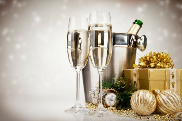 Weihnachtsgeschenk mit Champagner und Gläsern auf einem einfarbigen Hintergrund