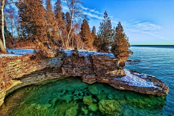 Costa rocosa del lago con árboles