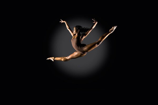 Ballet jump on a black background