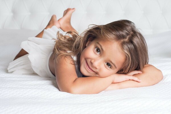 Beautiful baby on a white bed