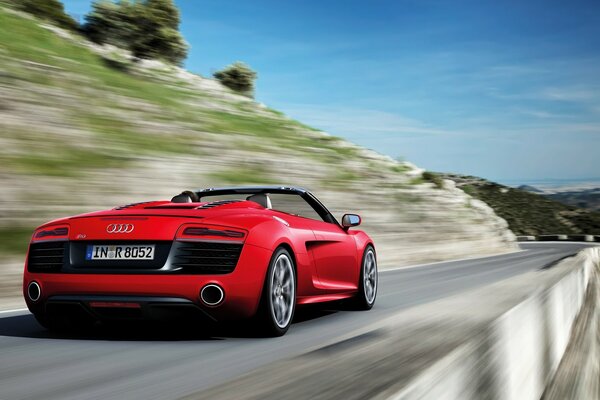 Voiture de sport rouge sur une route étroite