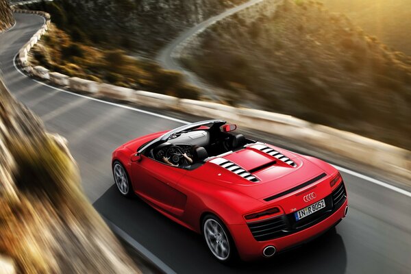 Coche deportivo rojo en una carretera estrecha y sinuosa