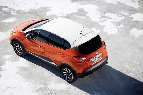 El auto de Renault, naranja con techo blanco, se para al sol