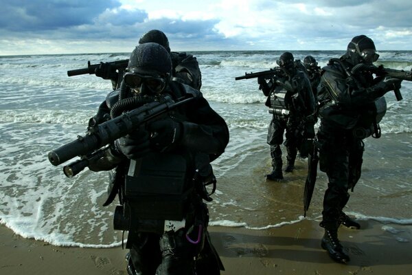 Special forces with weapons in their hands on the shore