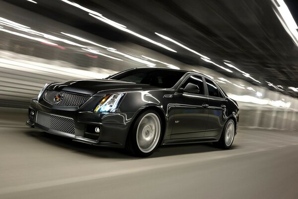 A black car rides in a tunnel