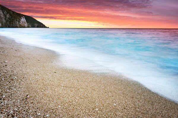 Sea and beach in summer at sunset