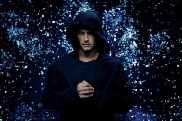 A man in a black hoodie on a bright background