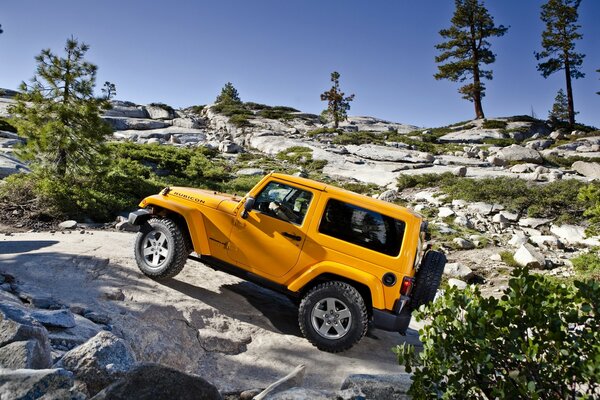 Gelber Jeep schleicht sich im Freien durch die Felsen