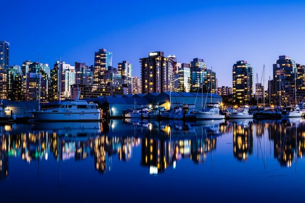 Evening skyscrapers are reflected in the water