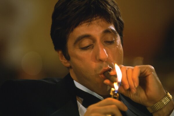 Al Pacino lights a cigar with a lighter