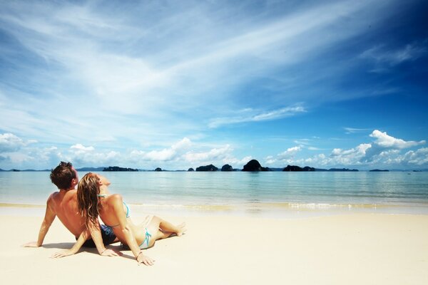 Joven pareja en la playa junto al mar