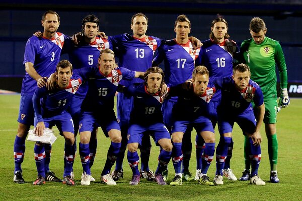 Equipe de futebol em uniforme azul no campo de futebol