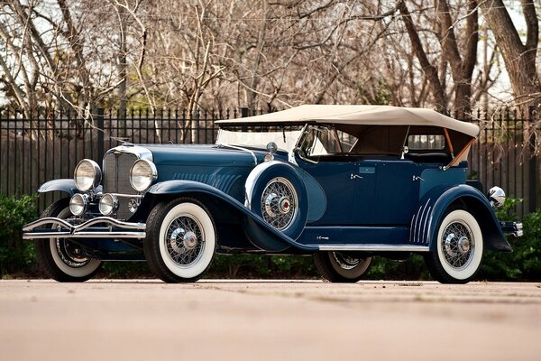 A passenger car of the early 20th century in blue and with a convertible top