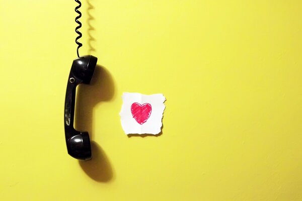 A telephone receiver and a note with a heart