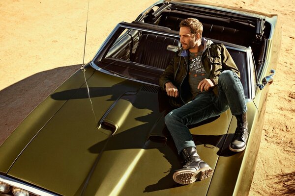 A handsome man on the hood of his car