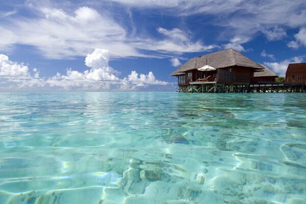 Ein Haus auf dem Wasser an einem tropischen Strand