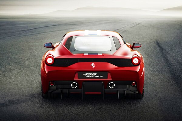 Red Ferrari rides on asphalt in fog