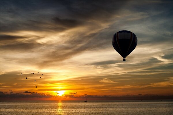 A balloon soars in the sky over the sea