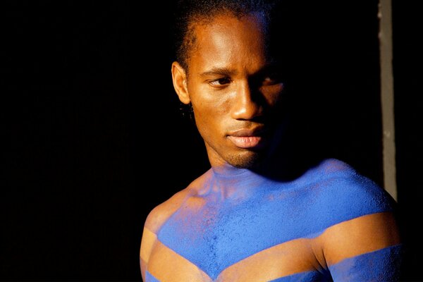 A black man with blue paint on his body