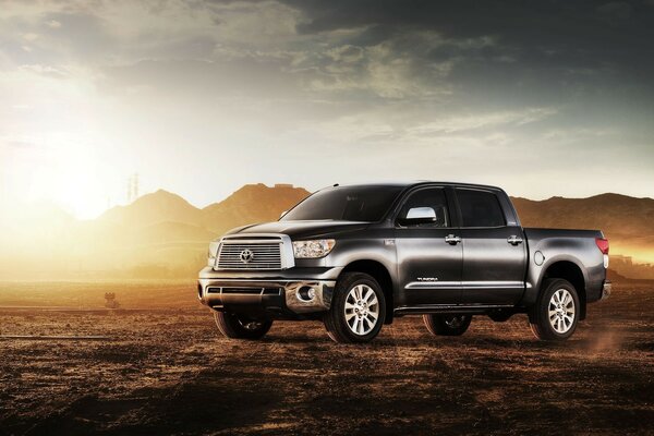 Cool gray-black pickup truck on the background of mountains