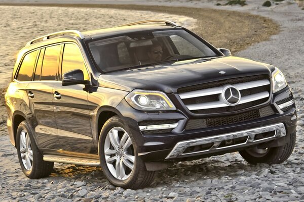 Voiture de marque Mercedes Benz debout sur une plage de pierre