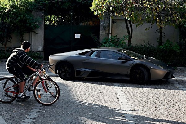 Voiture de sport et adolescent à vélo