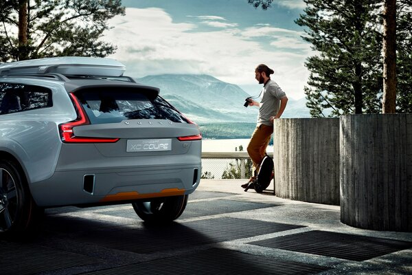 A man is waiting near his white car