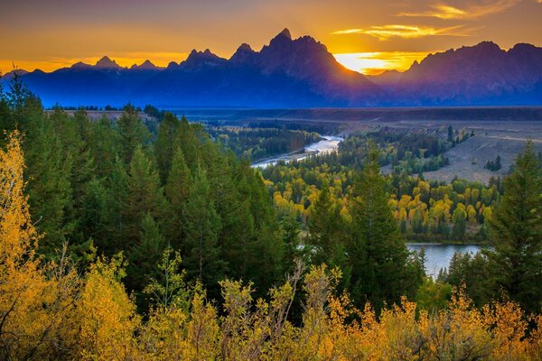 Puesta del sol más allá de la montaña sobre el bosque