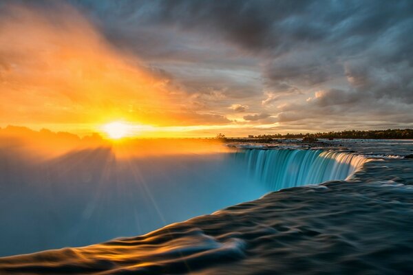 Cachoeira nebulosa ao pôr do sol com nuvens